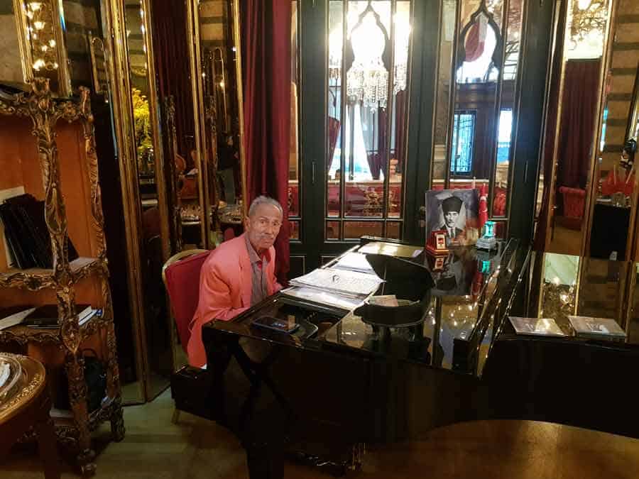 STILL PLAYING EVERY AFTERNOON AT THE AGE OF 92 – Ilham Gencer at his piano in the hotel's saloon 