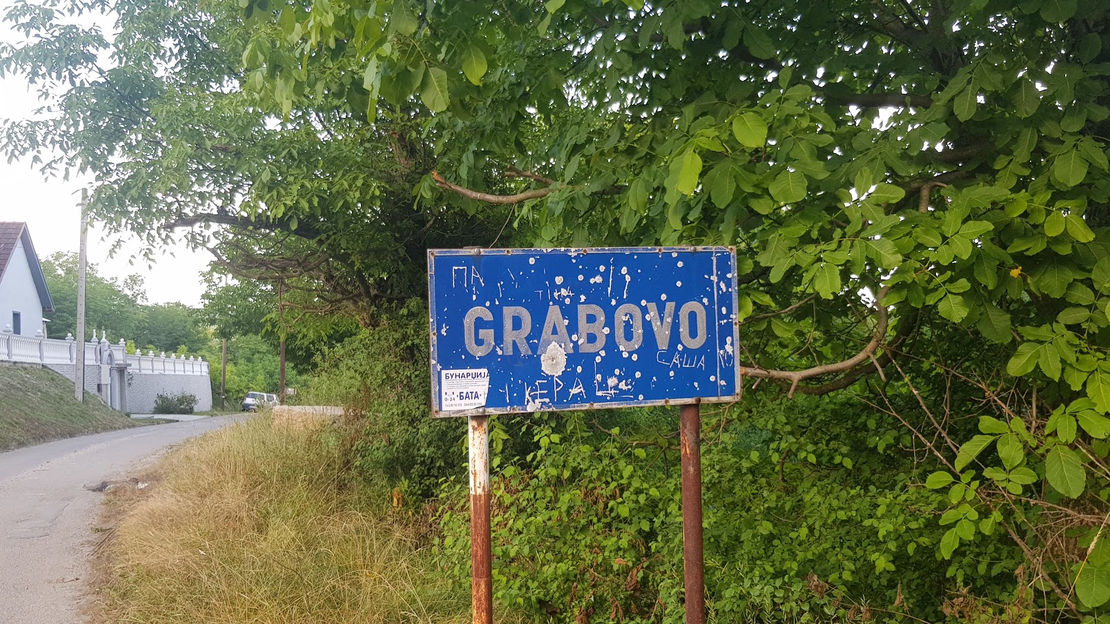 GRABOVO: Izrešetana tabla na ulazu u selo i jedna od napuštenih kuća